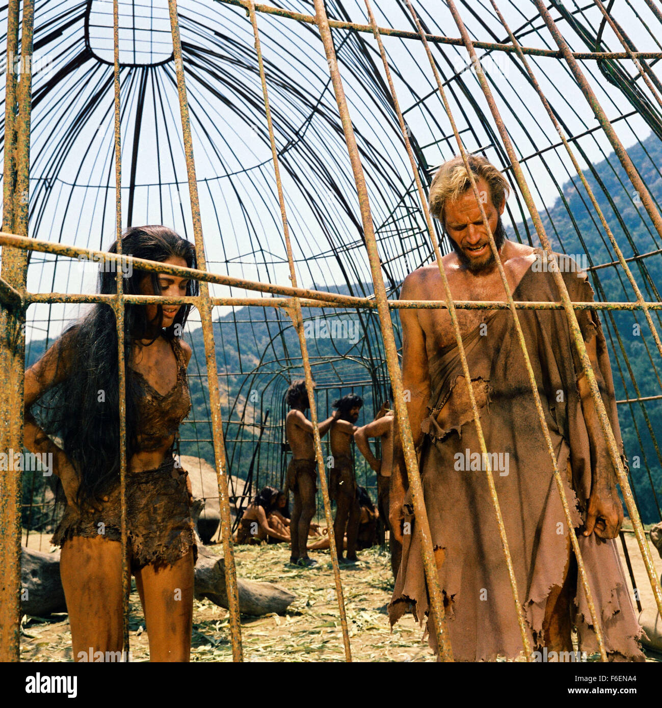 VERÖFFENTLICHT Datum: 8. Februar 1968. FILMTITEL: Planet der Affen. STUDIO: 20th Century Fox. PLOT: Taylor und zwei anderen Astronauten kommen aus dem tiefen Winterschlaf zu finden, dass ihr Schiff abgestürzt ist. Flucht mit wenig mehr als die Kleidung, die sie finden, dass sie auf einem Planeten gelandet wo sind Männer haben vor lingualen und unzivilisiert während Affen Rede und Technik gelernt. Taylor ist gefangen genommen und in die Stadt der Affen nach ihm die Kehle zu beschädigen, so dass er schweigt und nicht mit dem Affen kommunizieren. Bild: Schauspieler CHARLTON HESTON stars wie George Taylora und LINDA HAMILTON als Nova. Stockfoto