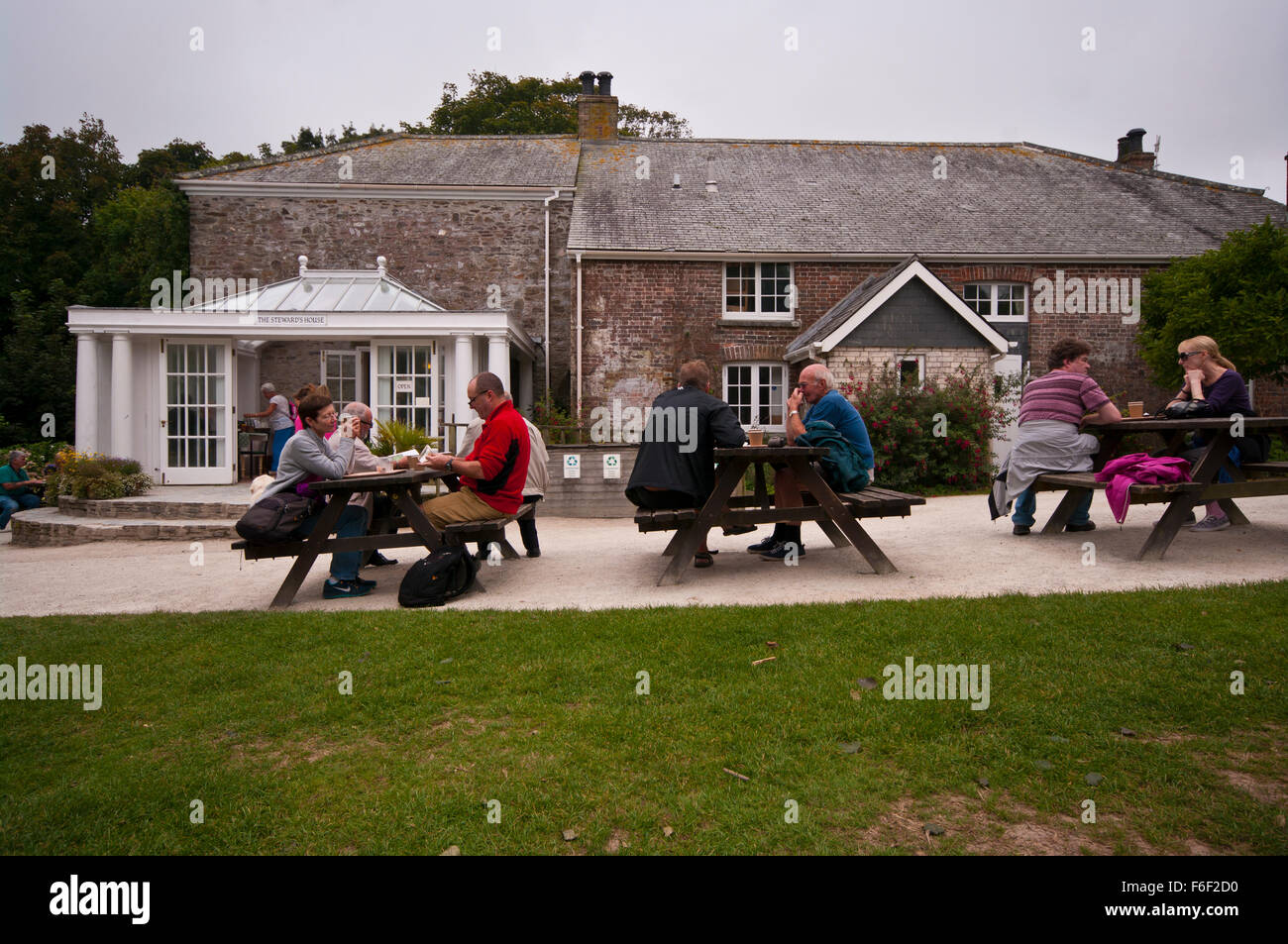 Touristen genießen einen Drink außerhalb der Stewards Haus Teestuben in den verlorenen Gärten von Heligan Cornwall England UK Stockfoto