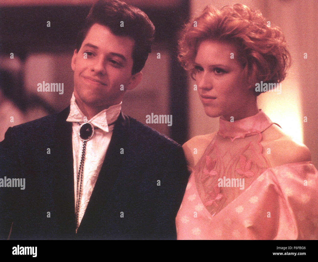 Erscheinungsdatum: 28. Februar 1986. Filmtitel: Pretty in Pink. STUDIO: Paramount Pictures. PLOT: Junge Andie gehört zu den nicht so beliebten Mädchen an der High School. Sie hängt in der Regel mit ihren Freundinnen Iona oder Duckie. Duckie hatte schon immer ein Auge auf sie, aber jetzt hat sie einen neuen Mann aus der Schule, Blane getroffen. Ist er einer der Jungs, reich und beliebt aber können die beiden Welten treffen? Im Bild: JON CRYER als Duckie (Phil Dale), MOLLY RINGWALD als Andie Walsh. Stockfoto