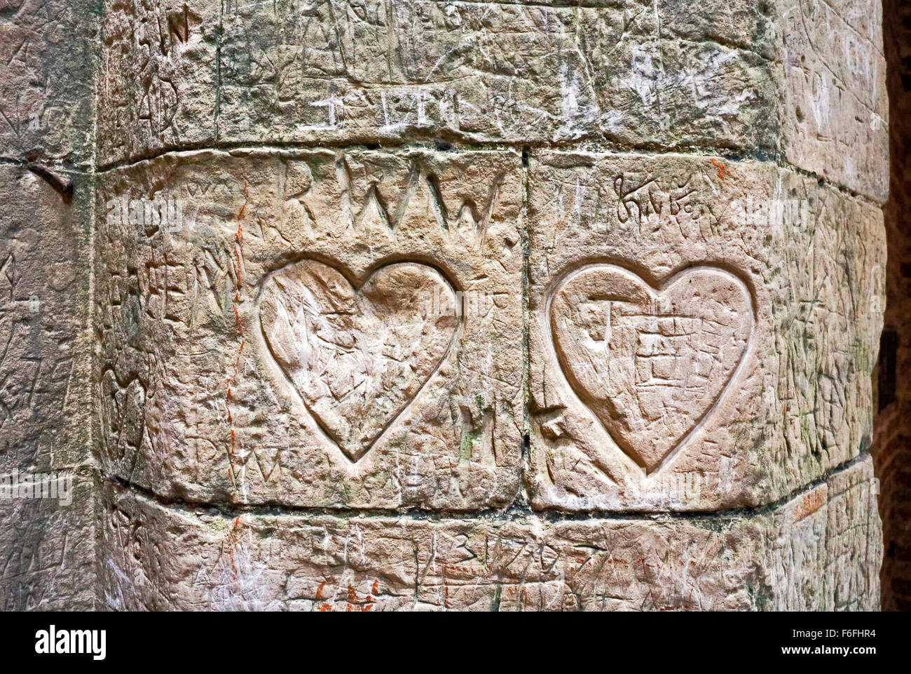 Herzförmige Graffiti geschnitzt in das Mauerwerk des zerstörten Torhauses St Benet Abtei in der Nähe von Ludham, Norfolk, England, UK. Stockfoto