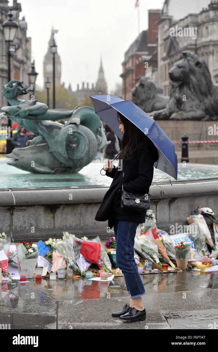 London, UK. 17. November 2015. Eine Frau reflektiert die Hommage an den getöteten in Paris Massaker am Brunnen am Trafalgar Square. Die schwere Regen, der Rest des Landes erlebt hat, erreicht London. Bildnachweis: JOHNNY ARMSTEAD/Alamy Live-Nachrichten Stockfoto