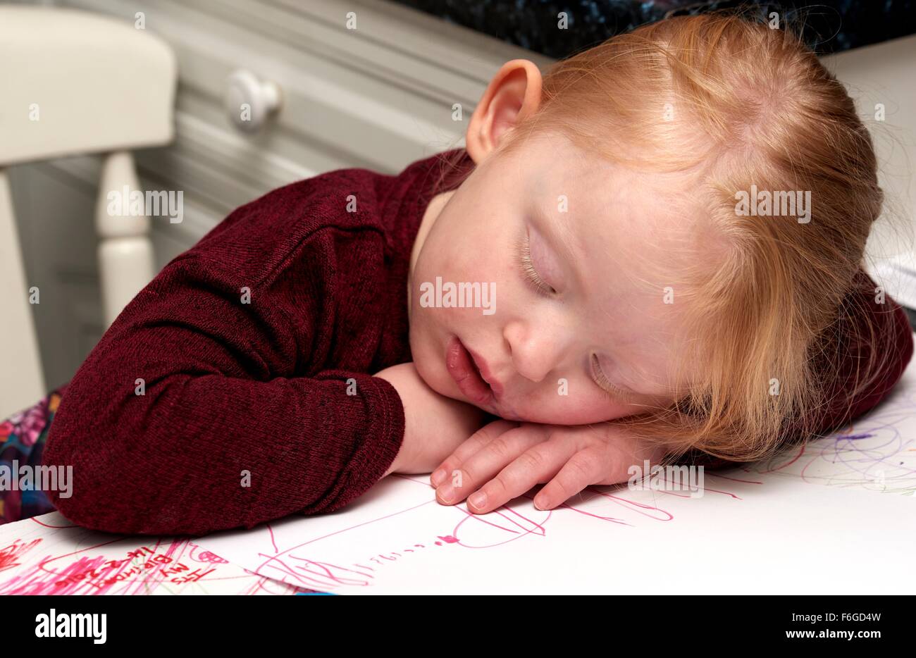 Ein 3-jähriges Mädchen schlafend auf einer Tischplatte mit ihrem Mund öffnen. Stockfoto
