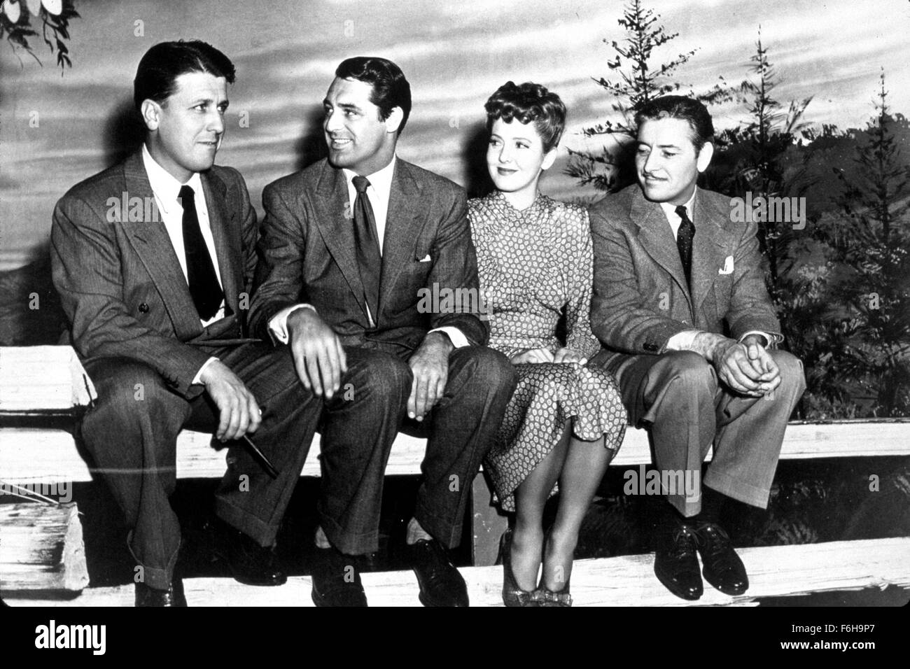 1942, Filmtitel: TALK OF THE TOWN, Regie: GEORGE STEVENS, Studio: COLUMBIA, im Bild: JEAN ARTHUR, RONALD COLMAN, CARY GRANT, GEORGE STEVENS, sitzen, Zaun, Anzug, DESINTERESSIERT, Direktor, HAND auf Knie, STUDIO. (Bild Kredit: SNAP) Stockfoto