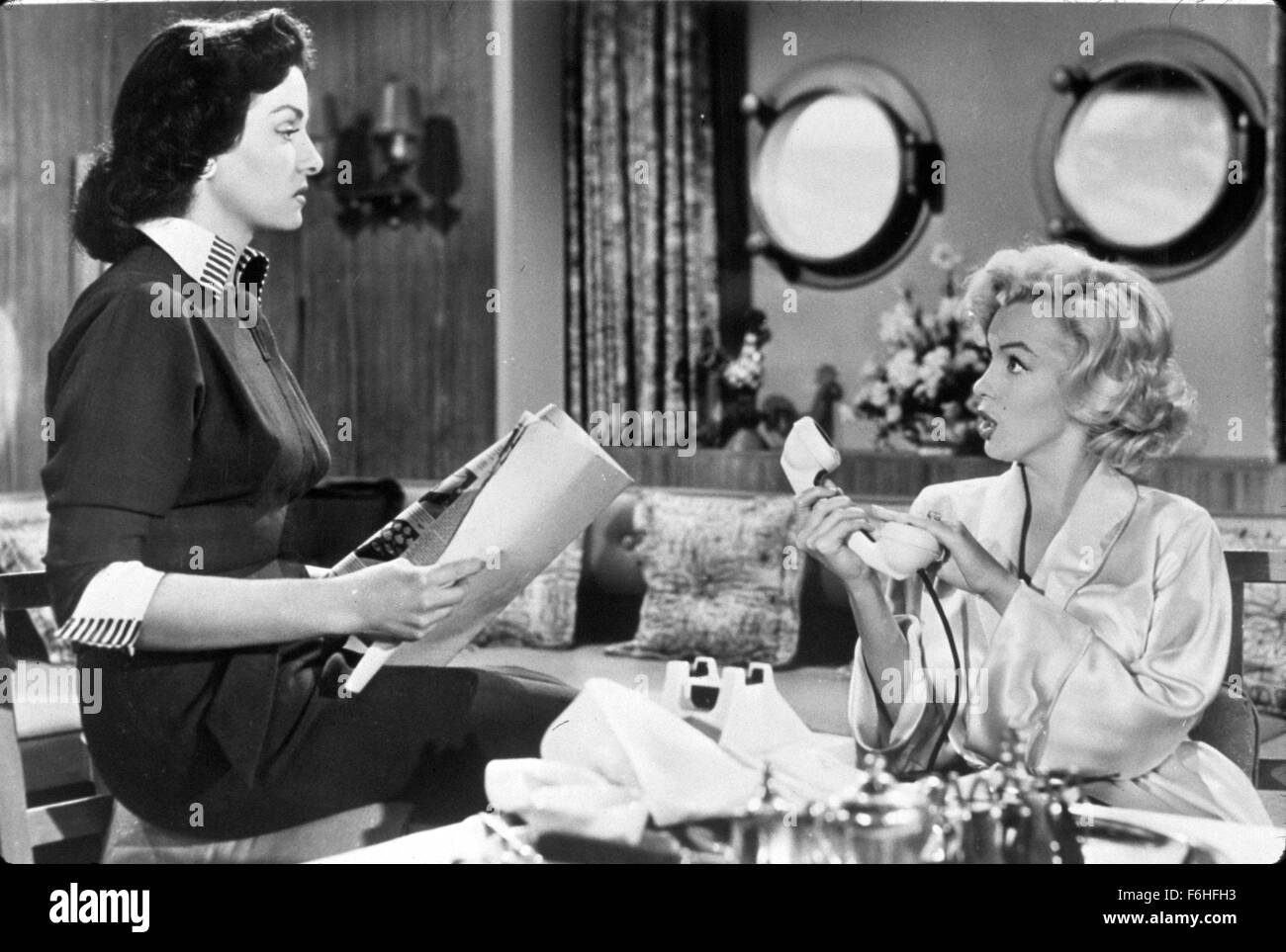 1953, Filmtitel: GENTLEMEN PREFER BLONDES, Regie: HOWARD HAWKS, Studio: FOX, abgebildet: 1953, Frühstück, MARILYN MONROE, JANE RUSSELL, lesen, telefonieren, auf Eis, Schreibtisch, Büro, GIRLS zeigen. (Bild Kredit: SNAP) Stockfoto