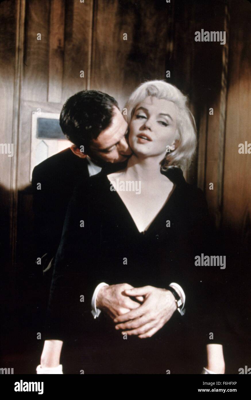 1960, Filmtitel: lassen Sie uns Liebe, Regie: GEORGE CUKOR, Studio: FOX, abgebildet: CON/Betrug, Lippen TRENNTEN, Liebe (verschiedene Klassen), MARILYN MONROE, YVES MONTAND, MUSICAL, Romantik, Streichelzoo, intim, Umarmung, männliche von hinten umarmen, küssen Hals. (Bild Kredit: SNAP) Stockfoto