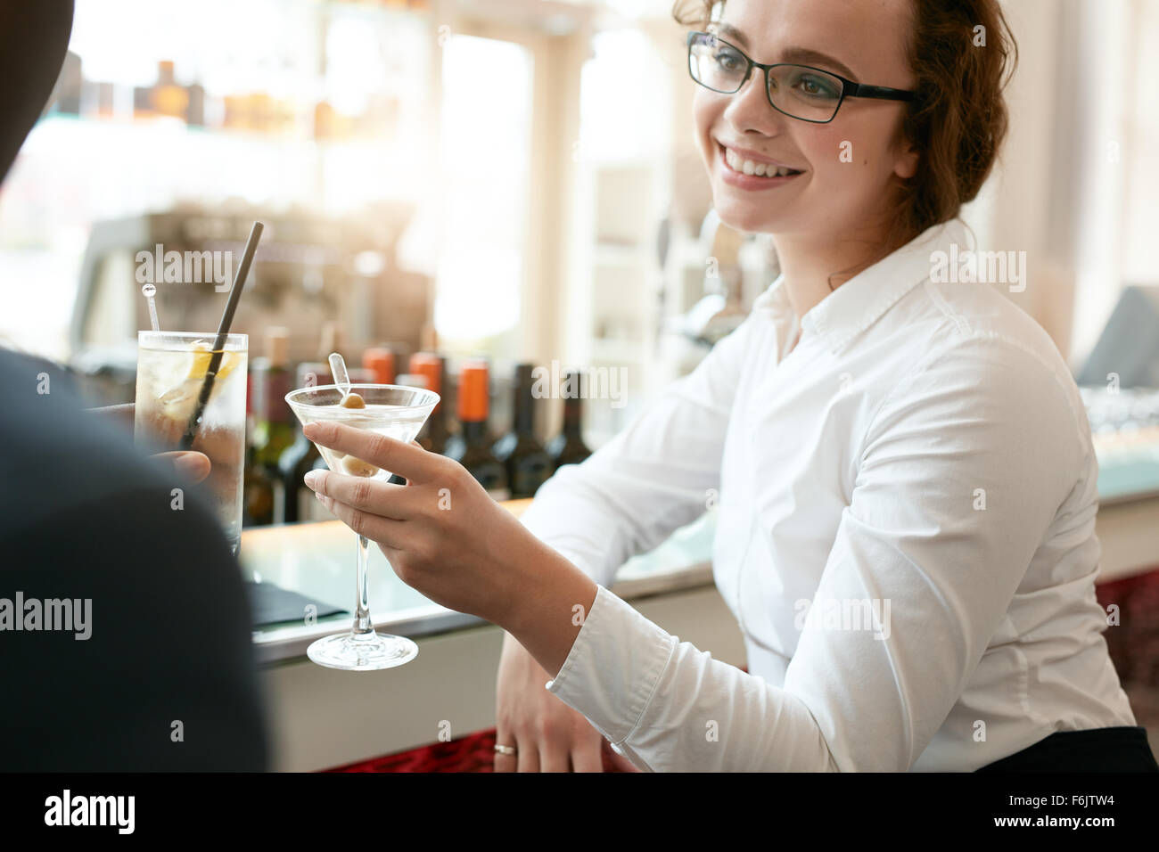 Junge Geschäftsfrau Toasten Getränke mit Kollegen im Café. Kaukasische Geschäftsfrau mit Partner ein Glas Getränk in Bar Stockfoto