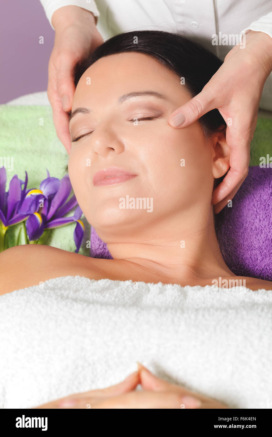 Frau, die Beauty-Behandlung. Schöne Frau empfangen Gesichtsmassage, Augen geschlossen, Nahaufnahme Stockfoto