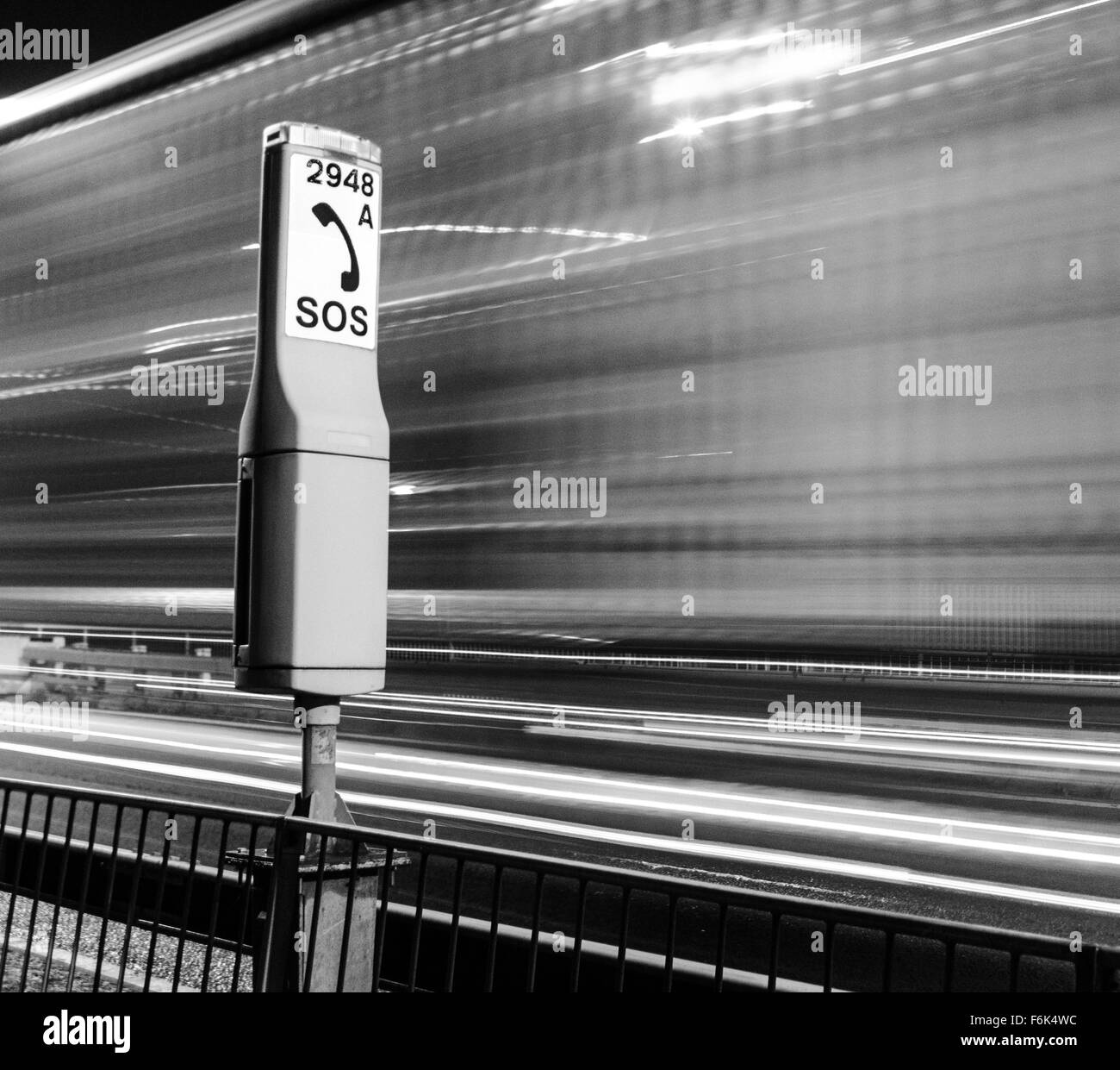 Notfall-Telefon in der Nacht von M48 Autobahn in der Nähe der Severn-Brücke. LKW Lichtspuren werden angezeigt. Stockfoto