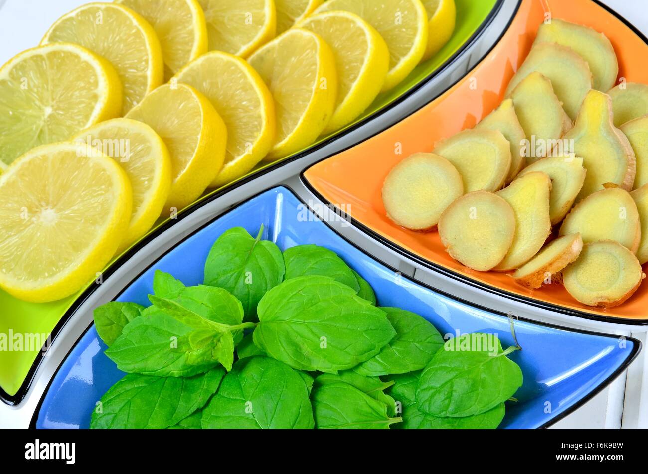 Zitrone, Ingwer und Minze Blätter in bunten Schalen. Stockfoto
