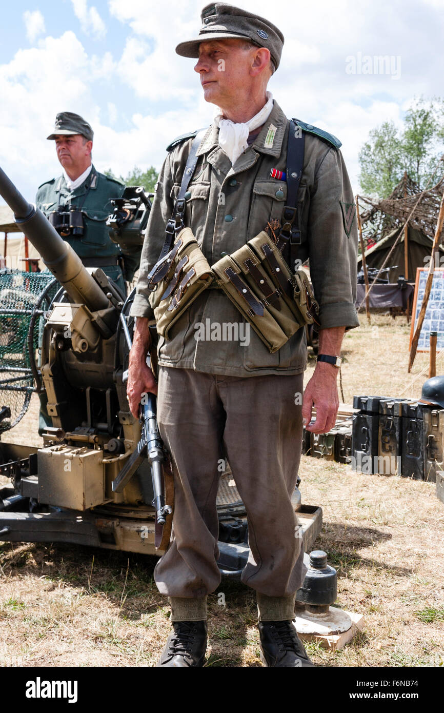 WW2re-enactment. Die deutsche Wehrmacht officer Standing im Kampf uniform, tragen M 38/40 Munition Beutel, und M43 Wollmütze. Holding sub Machine Gun. Stockfoto