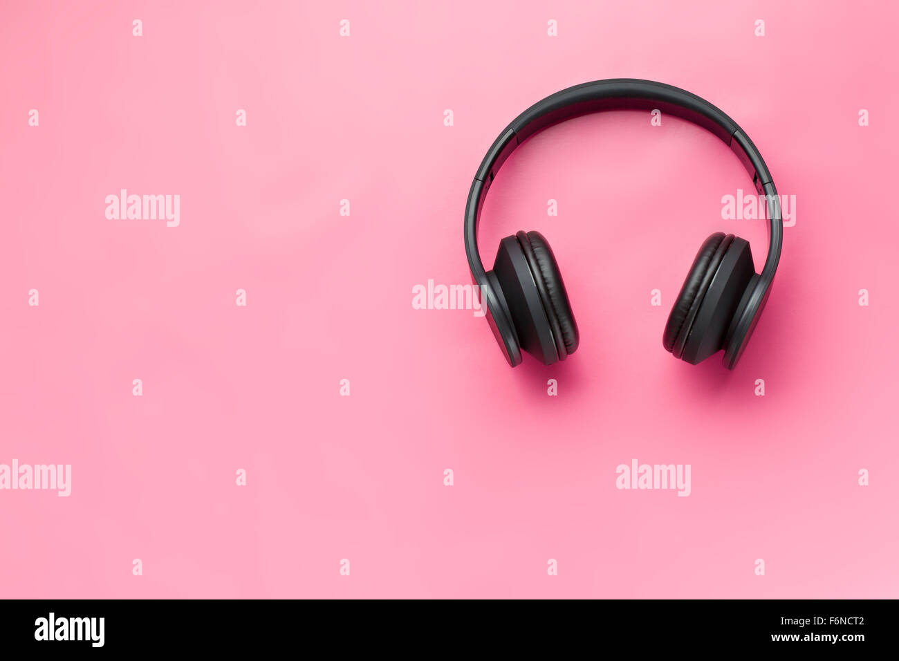 kabellose Kopfhörer auf rosa Hintergrund Stockfoto