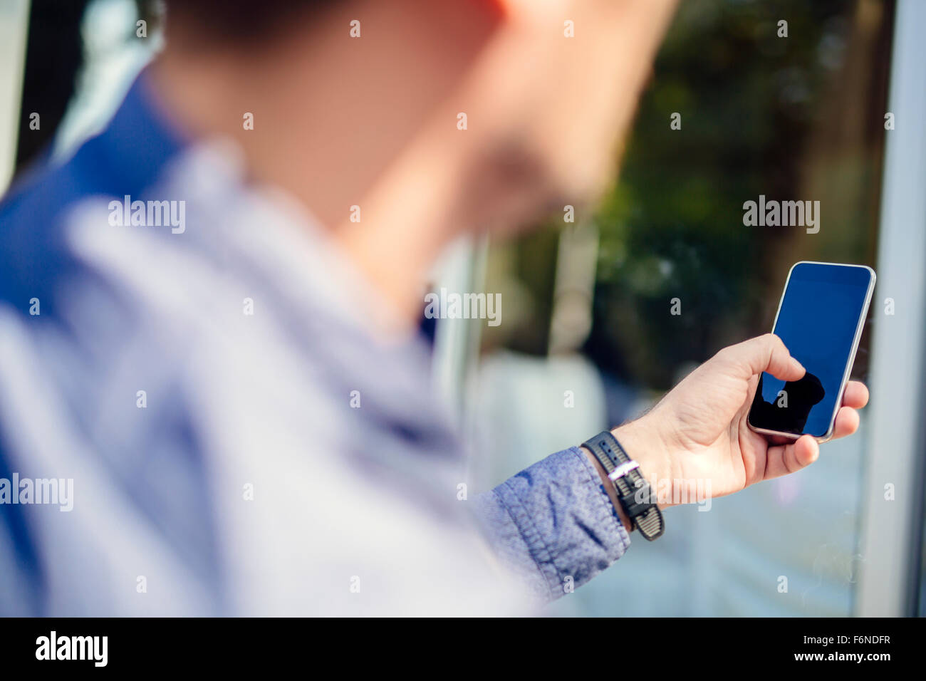 Mann hält Telefon im Freien und tippen Sie Stockfoto
