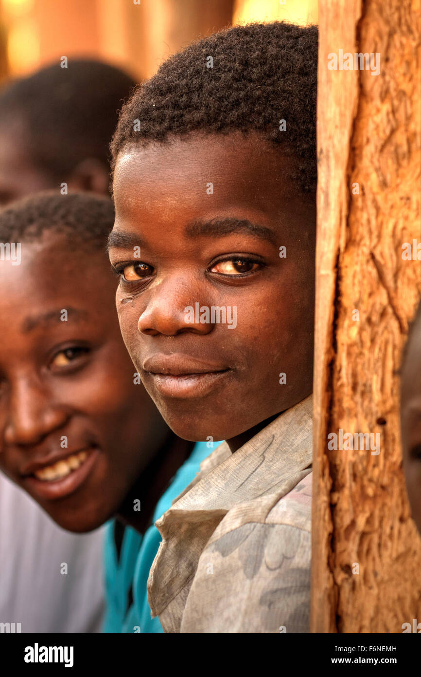 Malawischen Jungen spielen kämpfen mit einer Machete als Erwachsene Holz zu sammeln Stockfoto