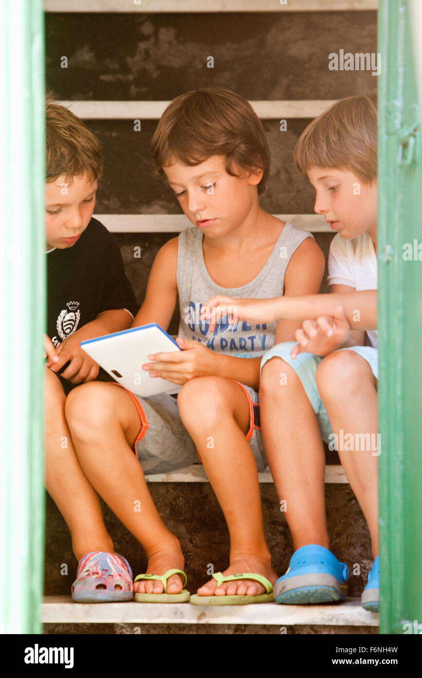 Italien Cinque Terre-Vernazza - drei Jungs mit Tablet auf Treppe Stockfoto