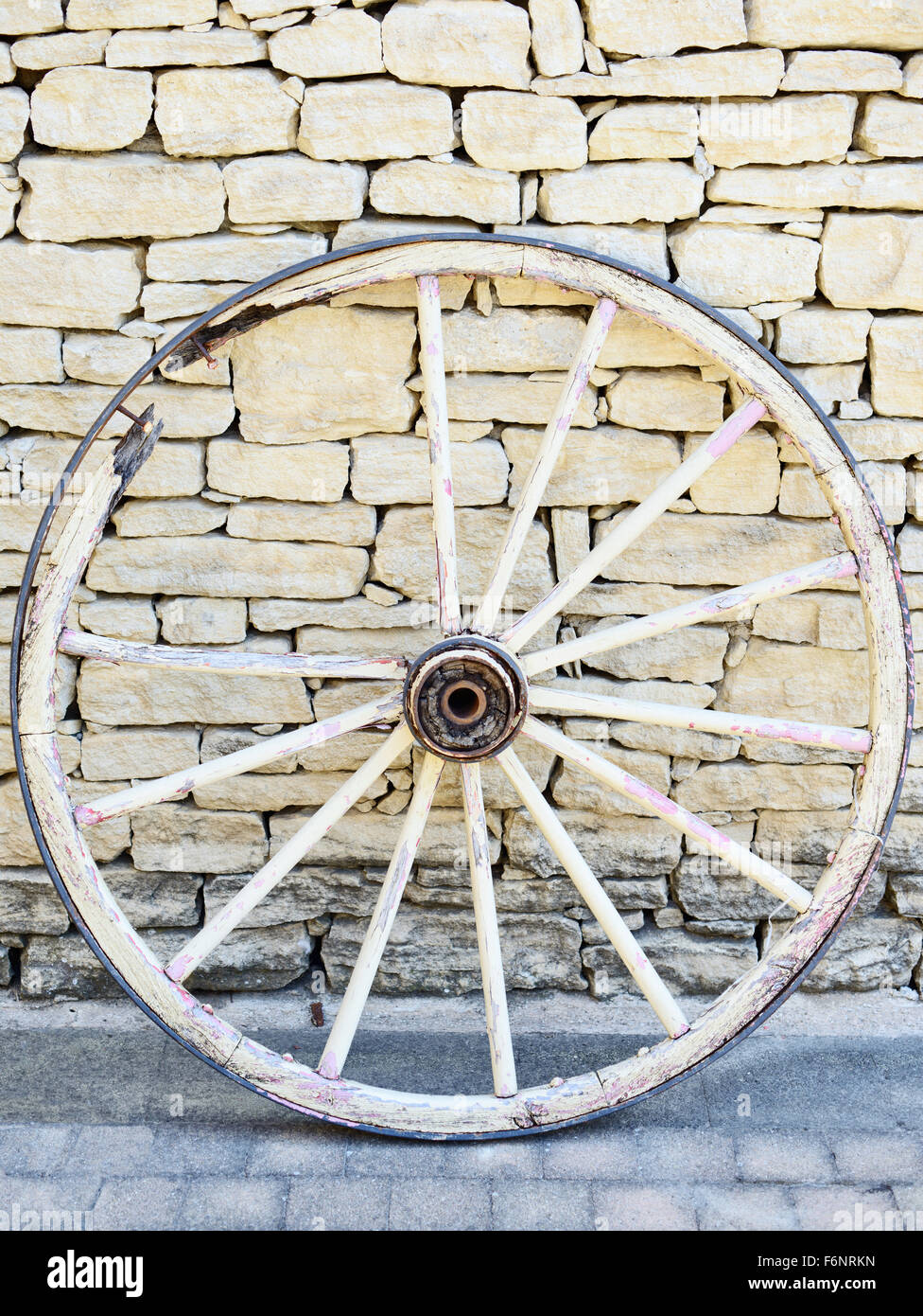 Alte Vintage gebrochen Holzrad in der Provence auf einem traditionellen Stein Wand Hintergrund. Frankreich. Stockfoto