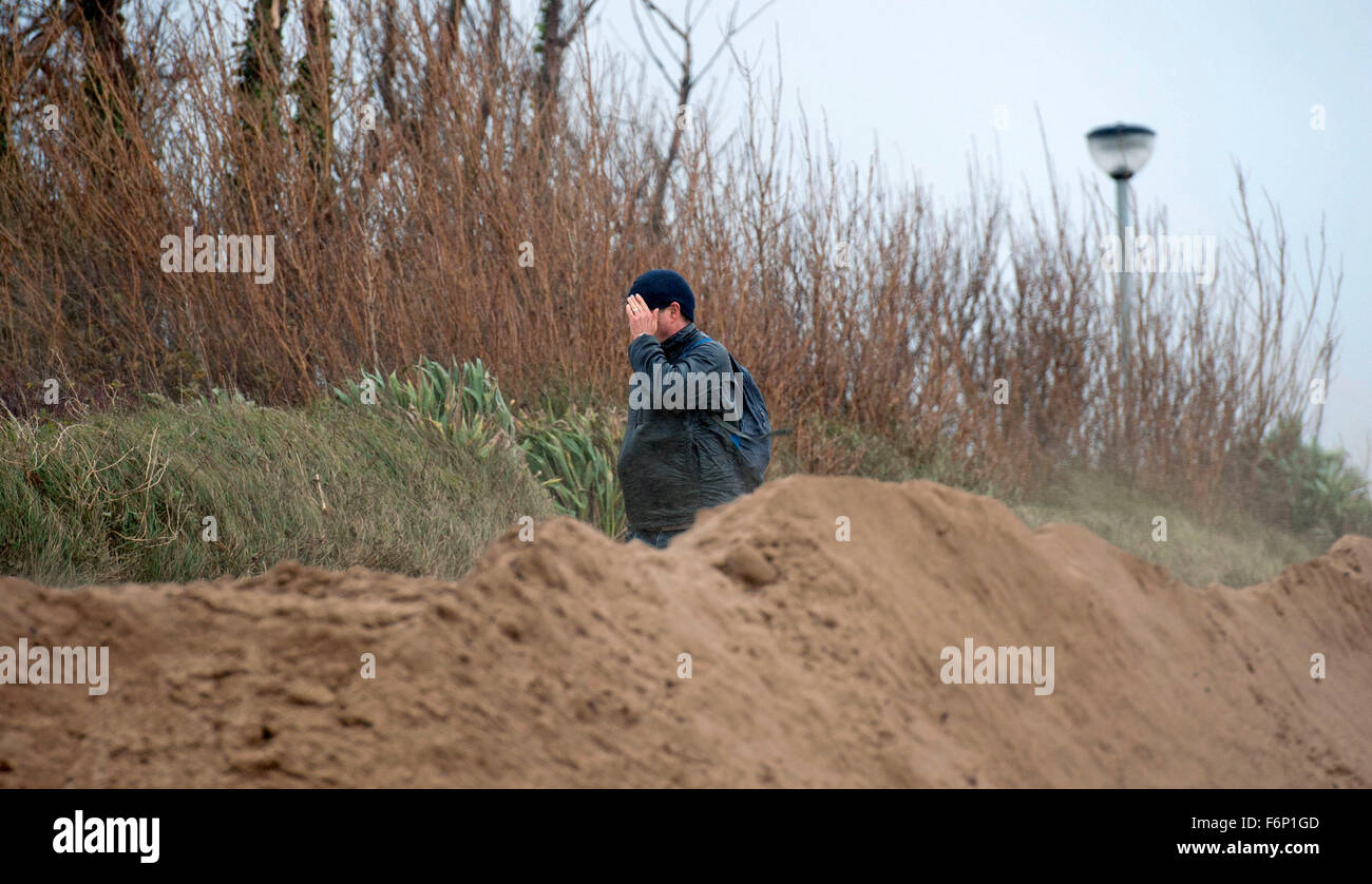 Swansea Bay - Swansea 18. November 2015: ein Spaziergänger schirmt sein Gesicht wie Sand am Strand auf der Küste Weg heute Nachmittag geblasen wird, wie die unruhige Wetter vom Sturm Barney anhält. Bildnachweis: Phil Rees/Alamy Live-Nachrichten Stockfoto