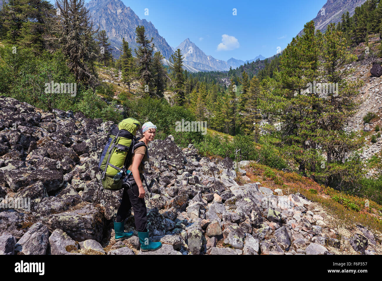 Vierzig Jahre Frau Forscher Tierwelt mit einem schweren Rucksack auf einem Hintergrund von Berg Wald Stockfoto