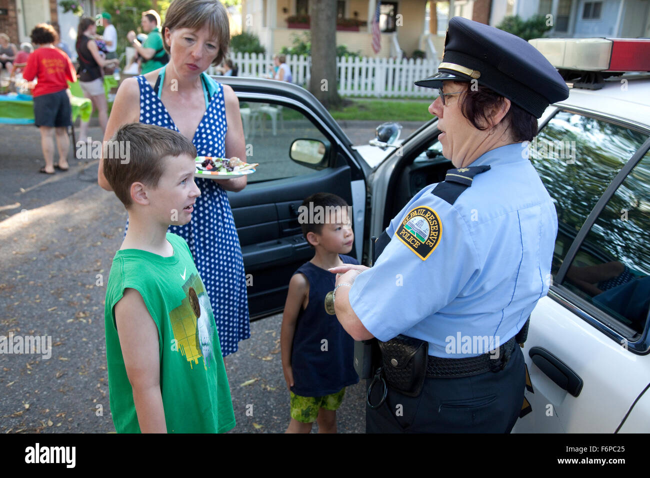 Zusätzliche Reserve Polizistin 9 Jahre alt, im Gespräch mit jungen Nachbarschaft "nehmen die Nacht zurück" Straßenfest. St Paul Minnesota MN USA Stockfoto