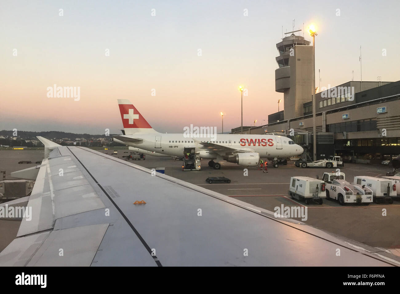 Swiss Airbus A319 und der Turm aus einem Flugzeug am Flughafen Zürich in den frühen Morgenstunden zu einem anderen anzeigen. Stockfoto