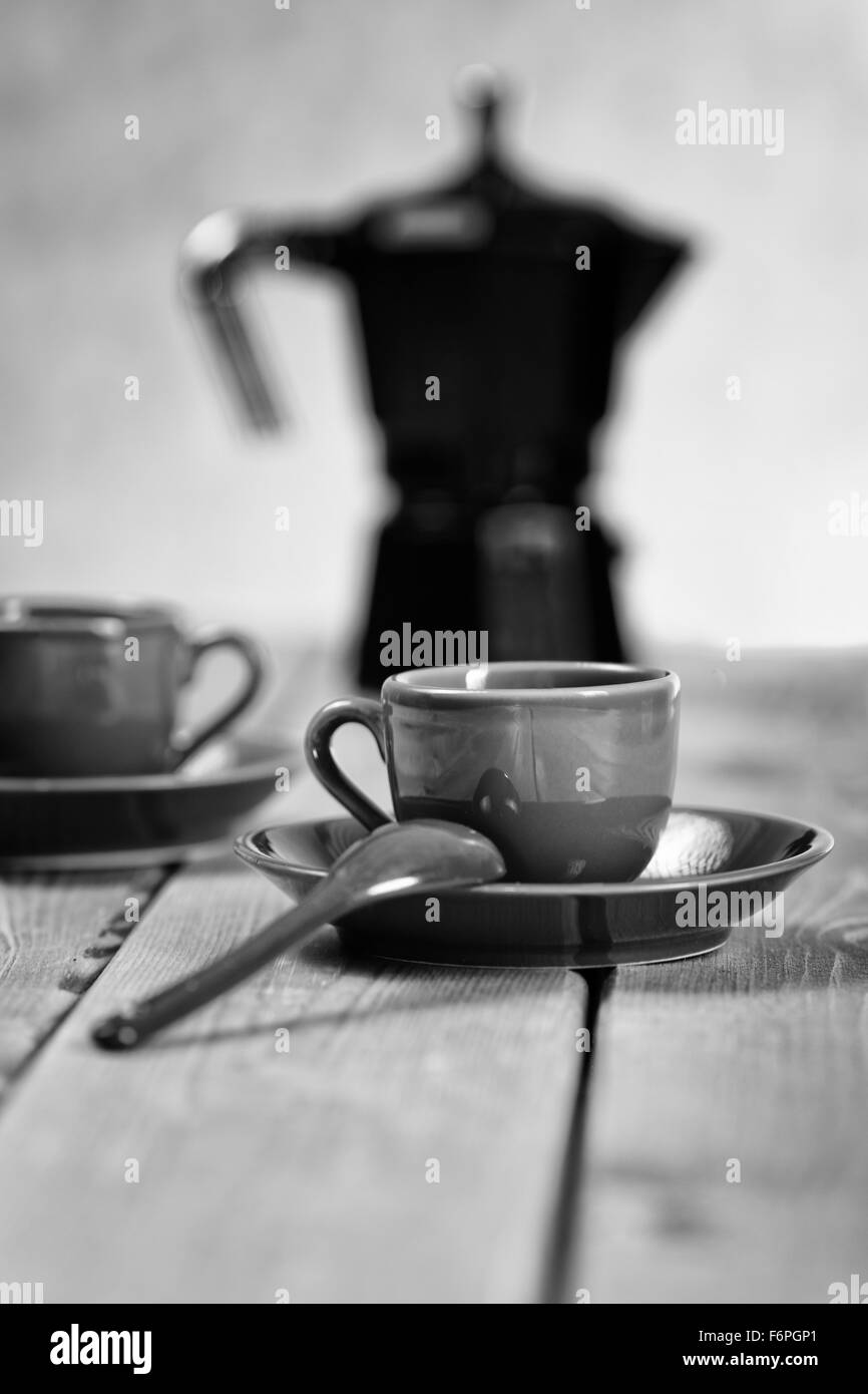 Tassen Kaffee und eine Kaffeekanne auf einem ländlichen Tisch Stockfoto