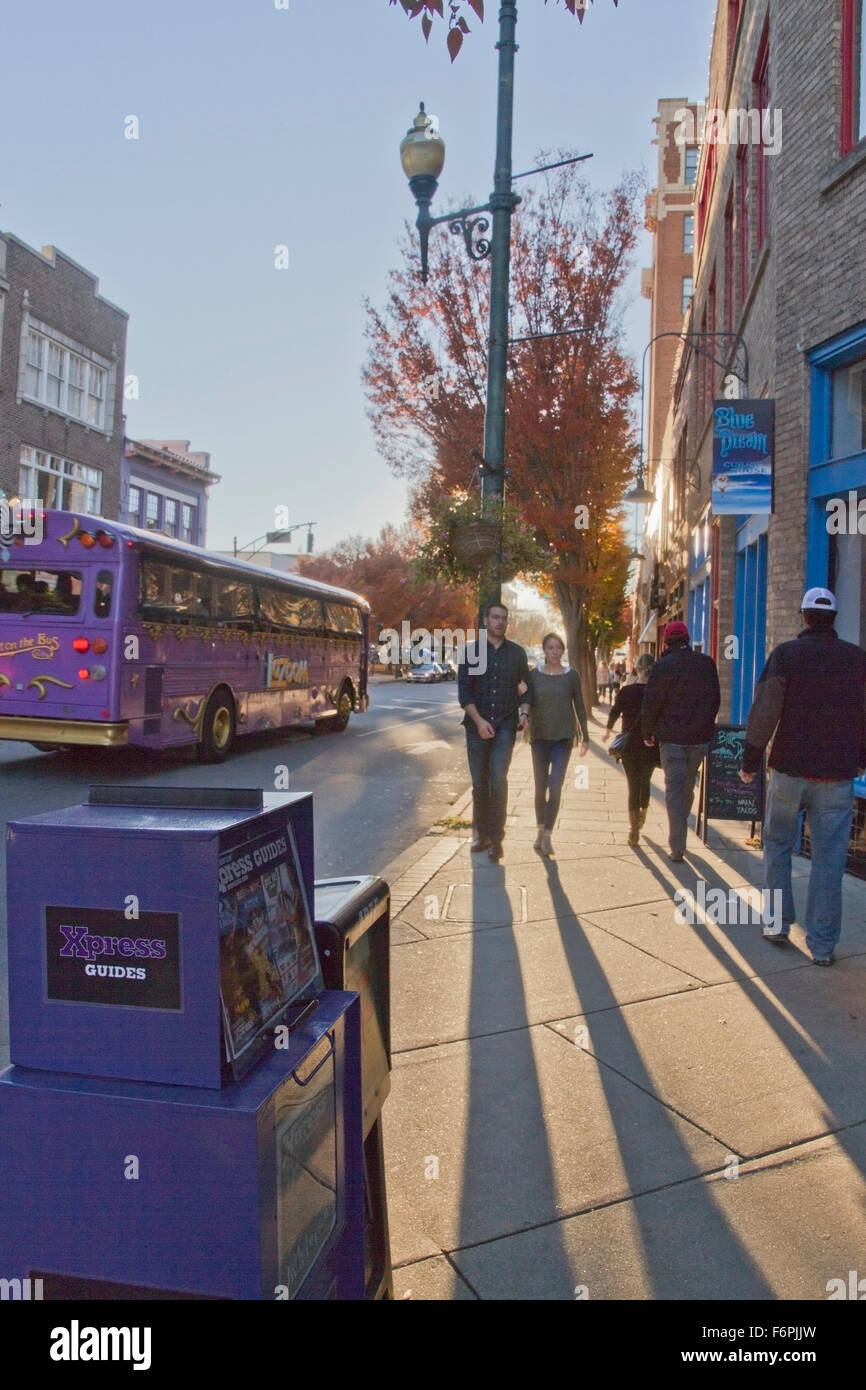 Eine entspannte Asheville Stadtstraße an einem späten Nachmittag im Herbst mit Menschen herumlaufen und die LaZoom Komödie Bus vorbei Stockfoto