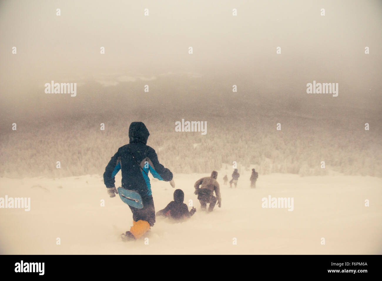 Kaukasische Wanderer gehen auf verschneiten Hügel Stockfoto