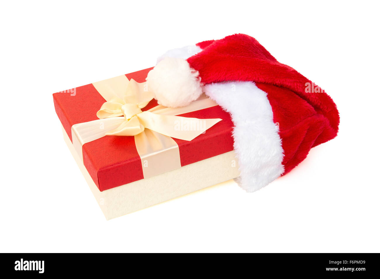 roten Geschenkbox mit Schleife abgedeckt durch eine Weihnachtsmann-Mütze Stockfoto