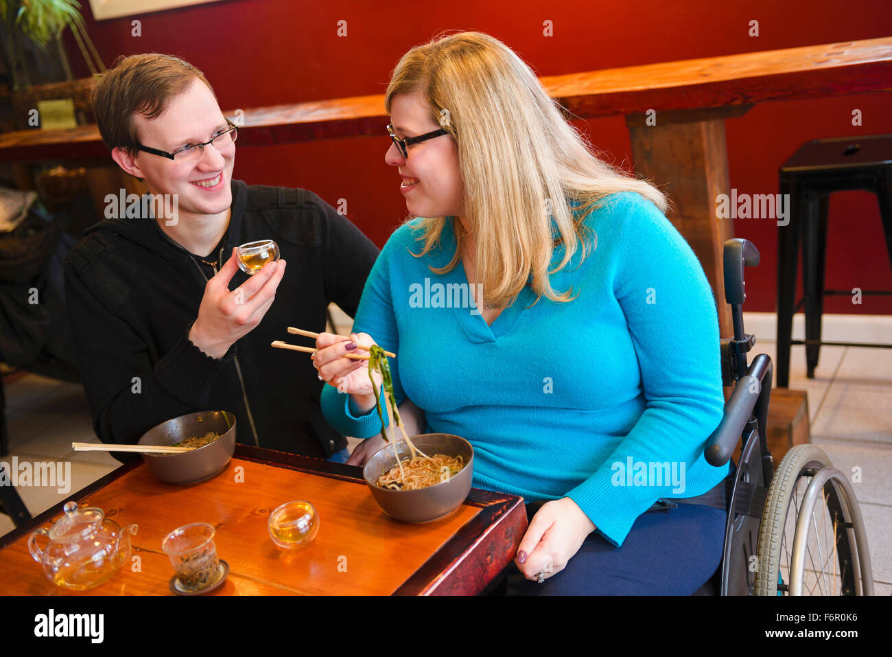 Querschnittsgelähmte und Freund essen Nudeln im Tee shop Stockfoto