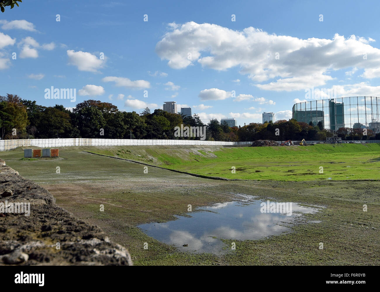 Tokio, Japan. 19. November 2015. Regen der vorangegangenen Nacht macht Pfützen hier und da auf die leere Seite des demontierten Nationalstadions inmitten der Nationen Kapital auf Donnerstag, 19. November 2015. Verspätete Bau von der Haupt-Veranstaltungsort für die Olympischen Spiele 2020 in Tokio und Paralympics beginnt Anfang 2017 unter ein straffer Zeitplan, nach Japan Sports Council. Bau wurde geschoben, nachdem Premierminister Shinzo Abe beschlossen, das ursprünglich gewählte Design wegen der damit verbundenen hohen Kosten Schrott. © Natsuki Sakai/AFLO/Alamy Live-Nachrichten Stockfoto