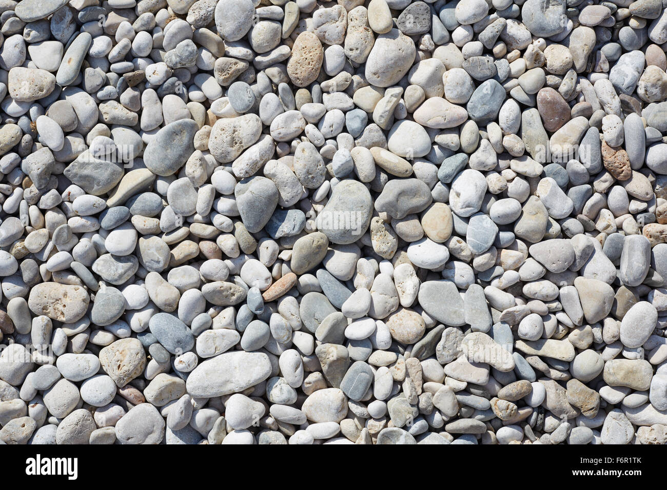 Kieselsteine am Strand, abstrakte Stein Hintergrund mit direkter Sonneneinstrahlung Stockfoto