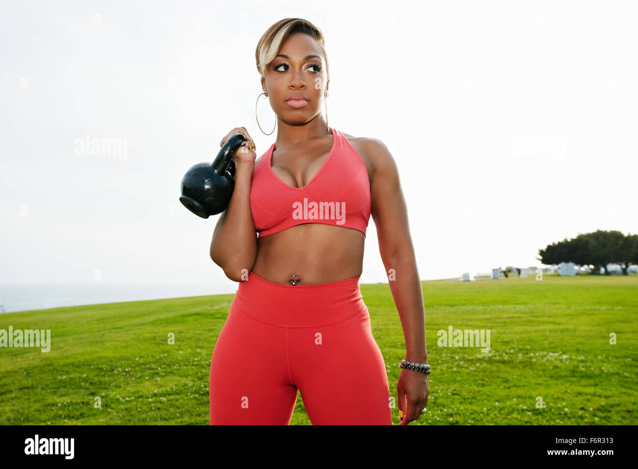 Schwarze Frau Heben von Gewichten im Feld Stockfoto