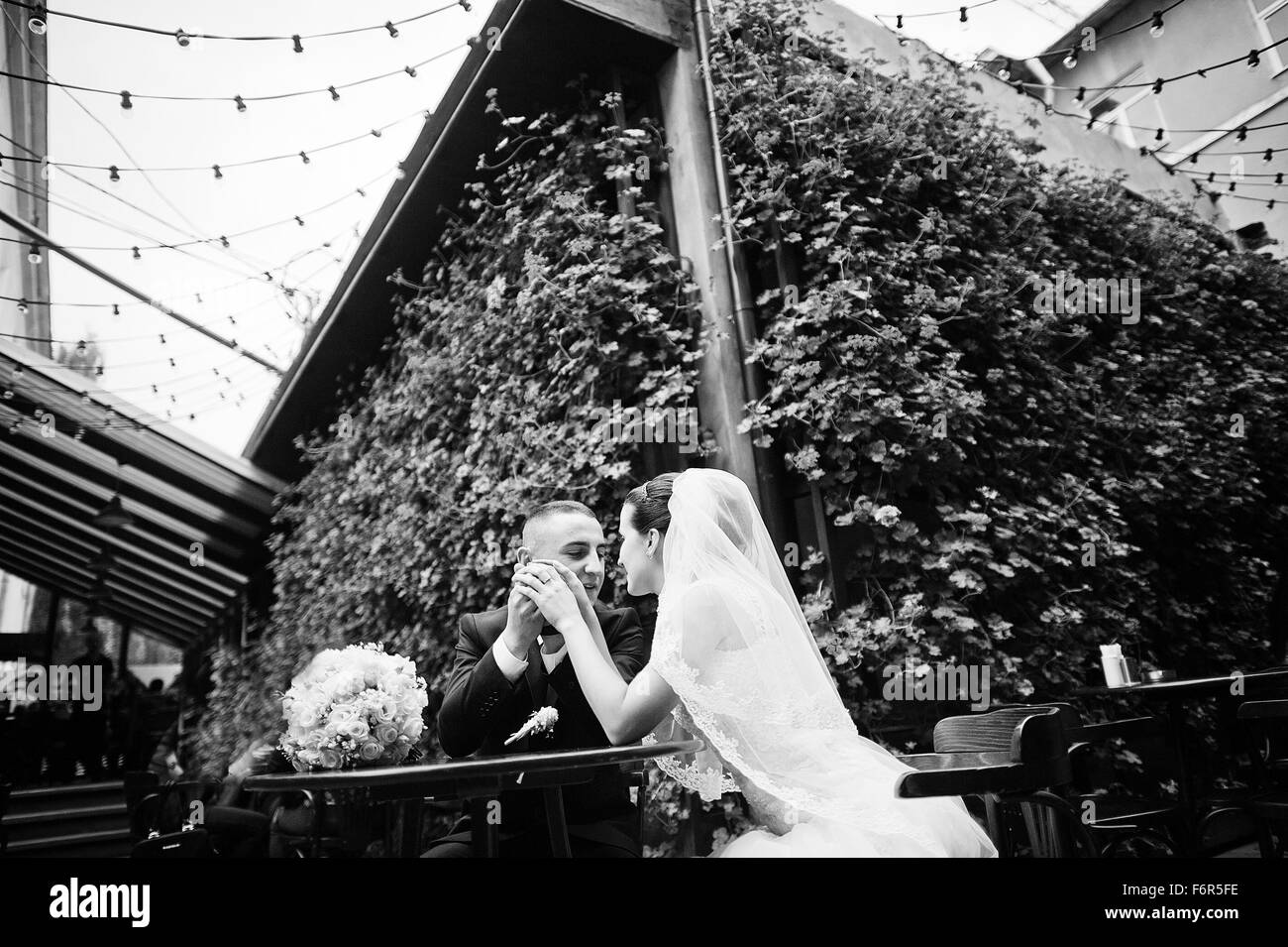 Frisch verheiratet auf Pub Hintergrundwand Blumen am Tisch sitzen Stockfoto