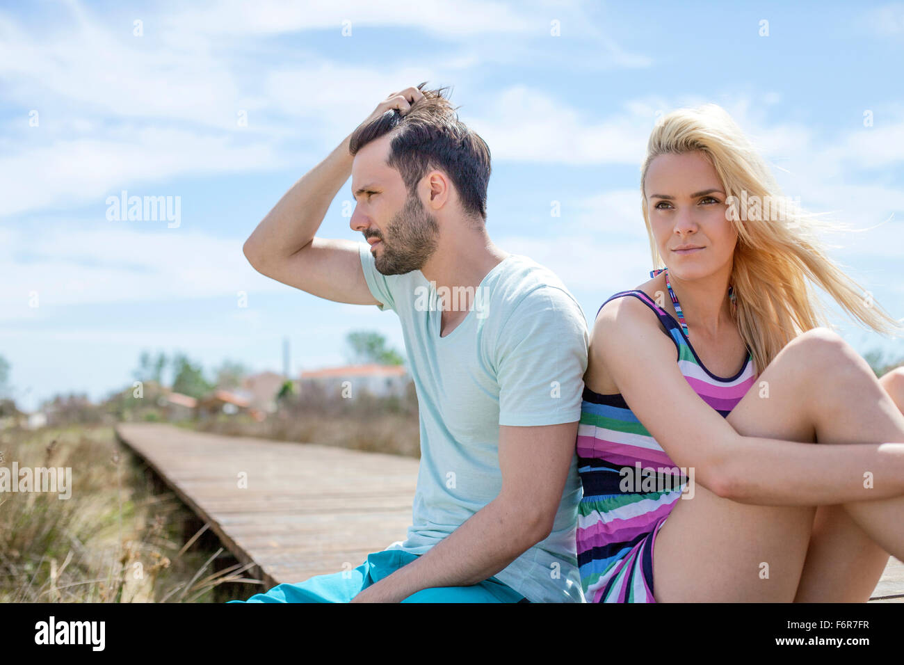 Porträt des jungen Paares am Strand mit Blick traurig Stockfoto