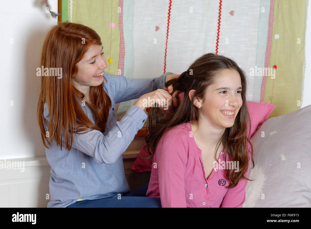 Mädchen im Teenageralter dabei gegenseitig die Haare, Zöpfe, Deutschland Stockfoto
