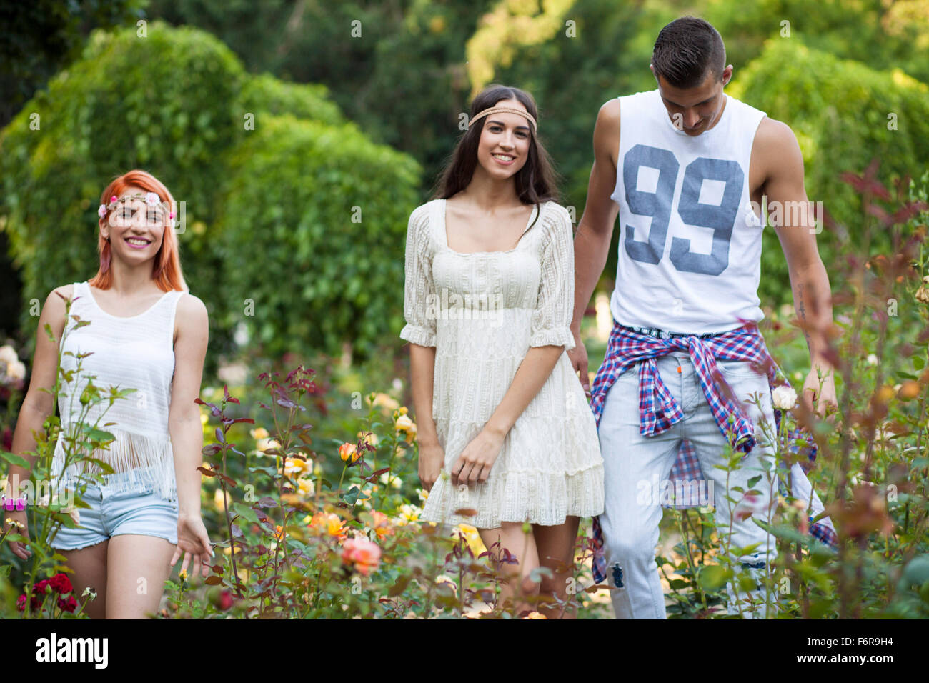 Junge Menschen im Hippie-Stil-Mode laufen im Stadtpark Stockfoto