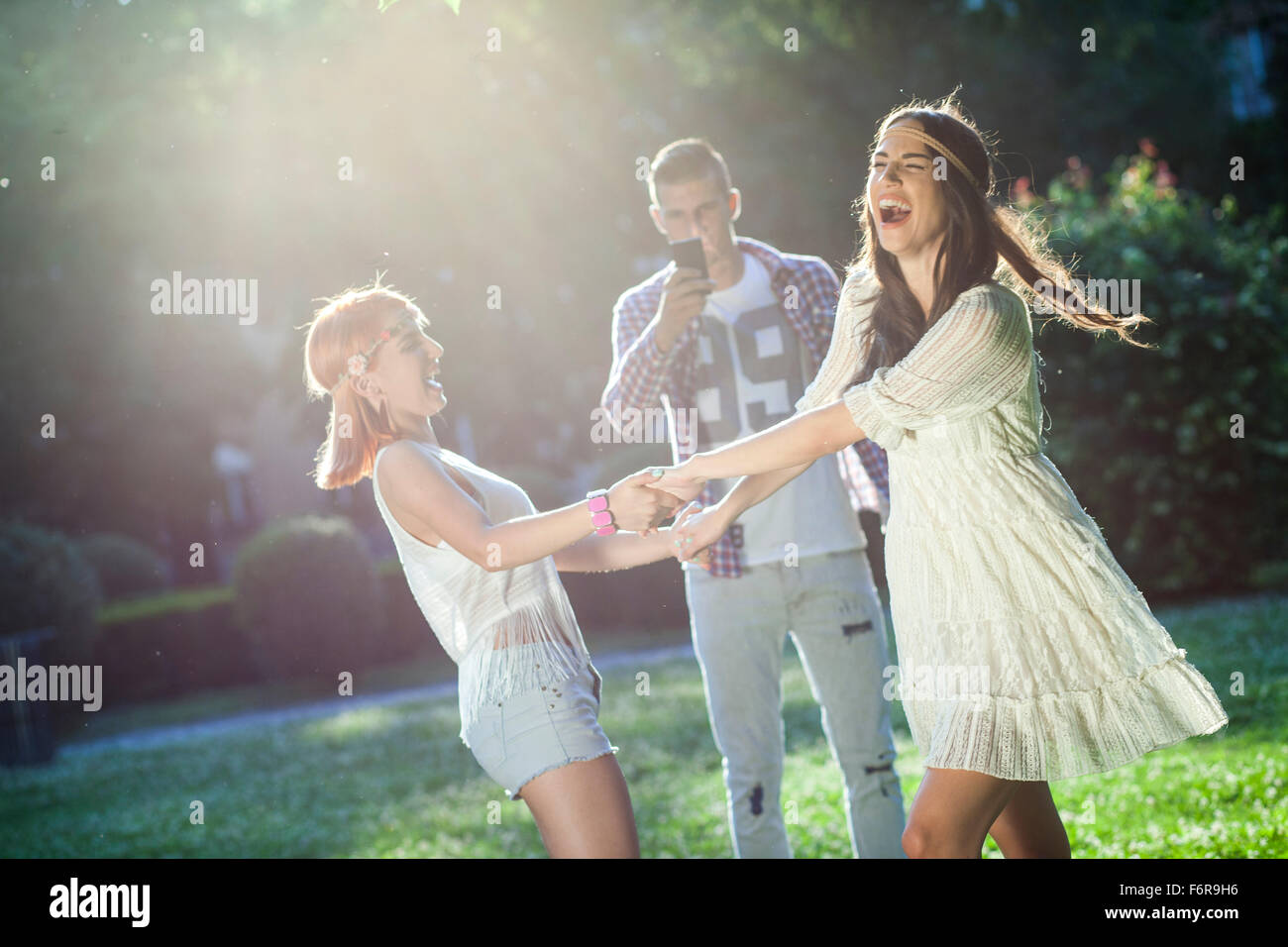 Junge Menschen in Mode im Hippie-Stil tanzen im Stadtpark Stockfoto