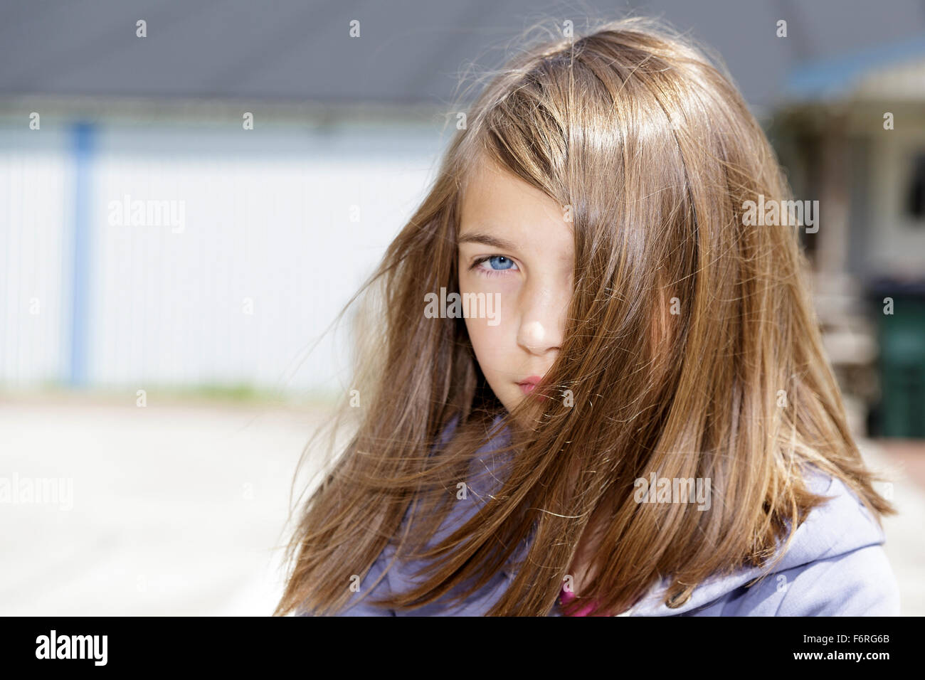 Junge Brünette lange Haare pre-adolecsent Mädchen an der Kamera, die mit einer Haltung im Freien portrait Model Release: Ja. Property Release: Nein. Stockfoto