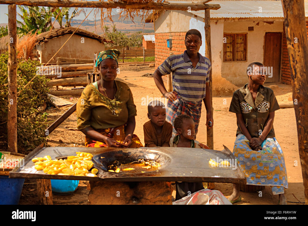 Verkauf von Chips Frauen gebraten in einer handgefertigten Friteuse von der Seite der Straße in das Dorf Tsumba, Flugfeld, Malawi, Afrika Stockfoto