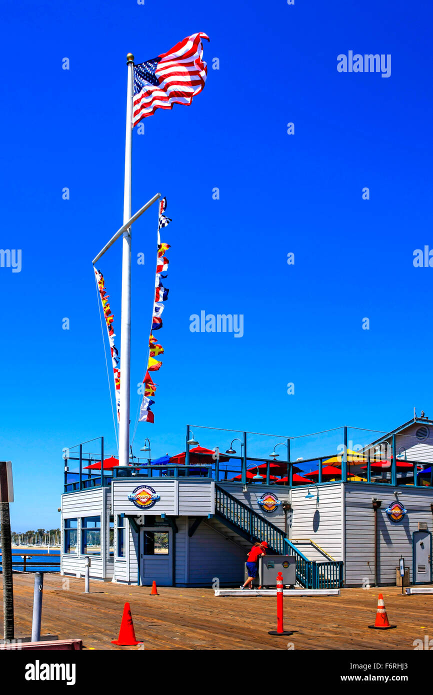 Nautische Wimpel und die amerikanische Flagge fliegen über Longboards Grill-Restaurant am Ende des Stearns Wharf in Santa Barbara Stockfoto