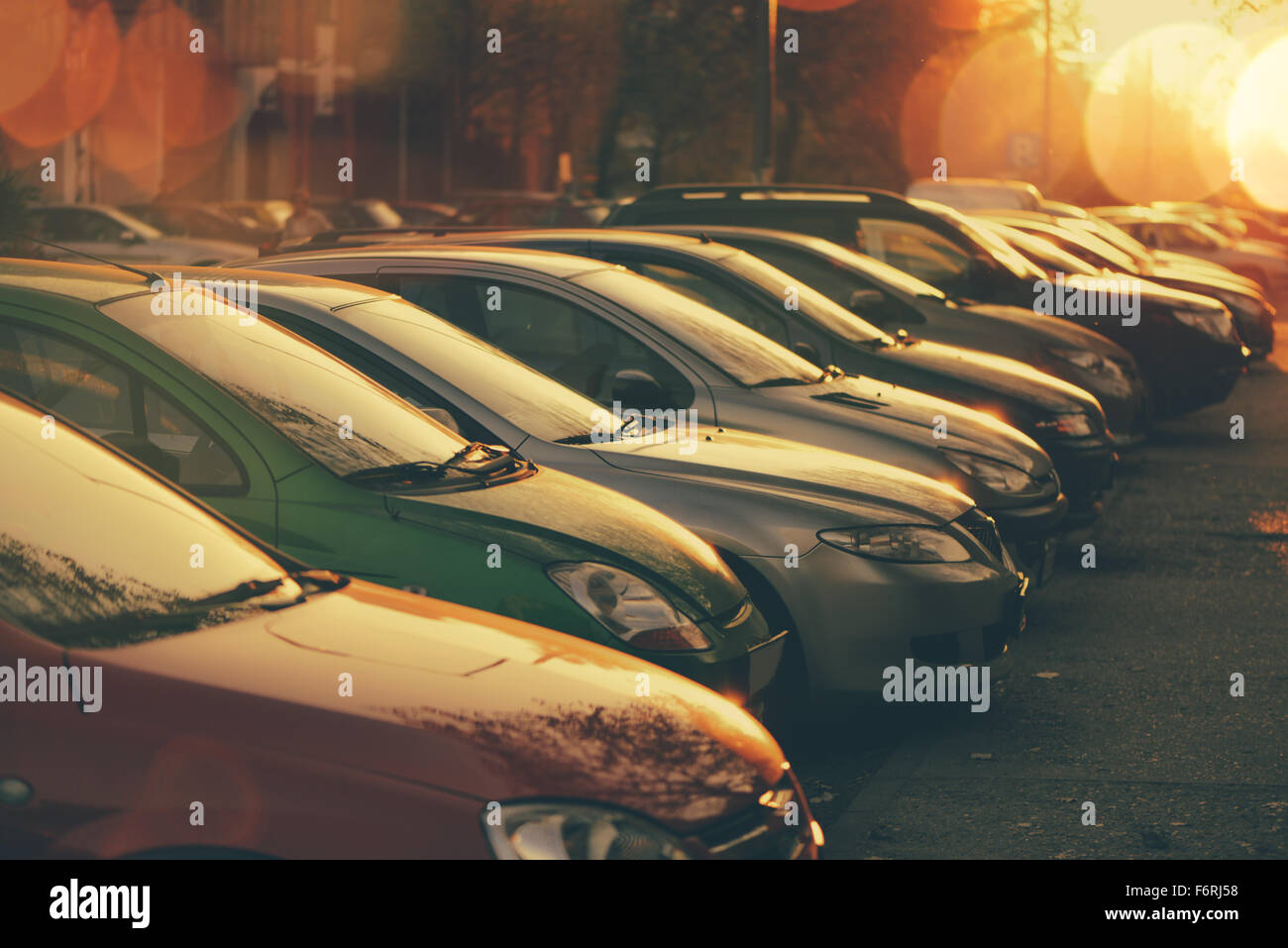 Reihen von Autos geparkt in Wohnviertel im Sonnenuntergang, Retro-getönten Bild mit Lens Flare und Bokeh Licht, selektiven Fokus Stockfoto