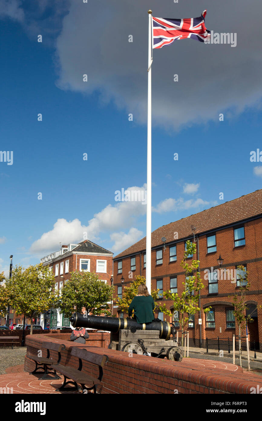 Großbritannien, England, Yorkshire, Hull, Princes Dock Road, Frau saß auf Meer Kanone unter Union Jack Flagge Stockfoto