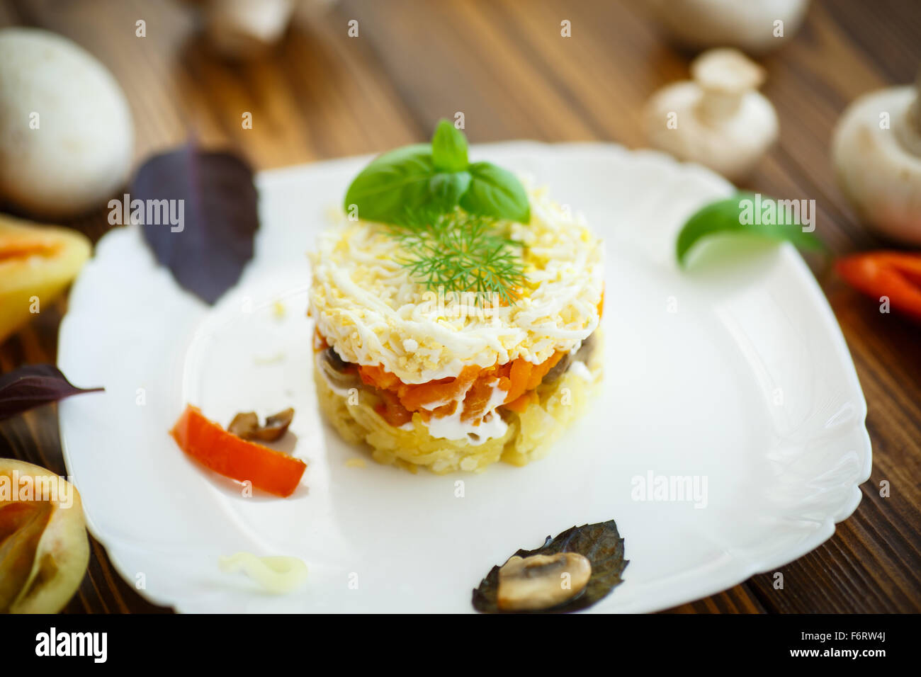 geschichteten Salat mit Pilzen und Gemüse in eine Schüssel geben Stockfoto