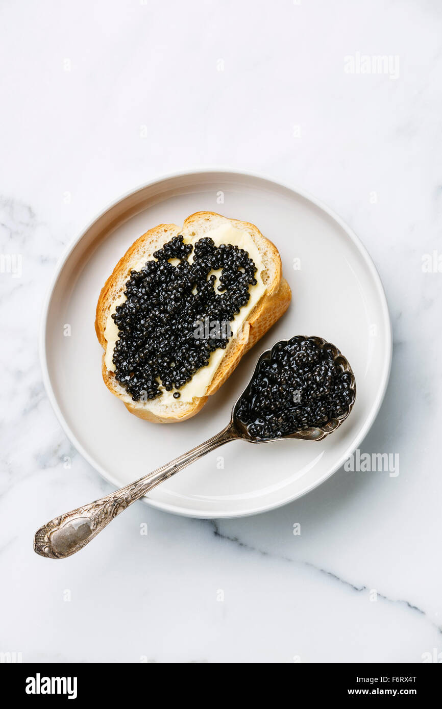 Stör schwarzen Kaviar Sandwich und Löffel auf weißem Marmor-Hintergrund Stockfoto
