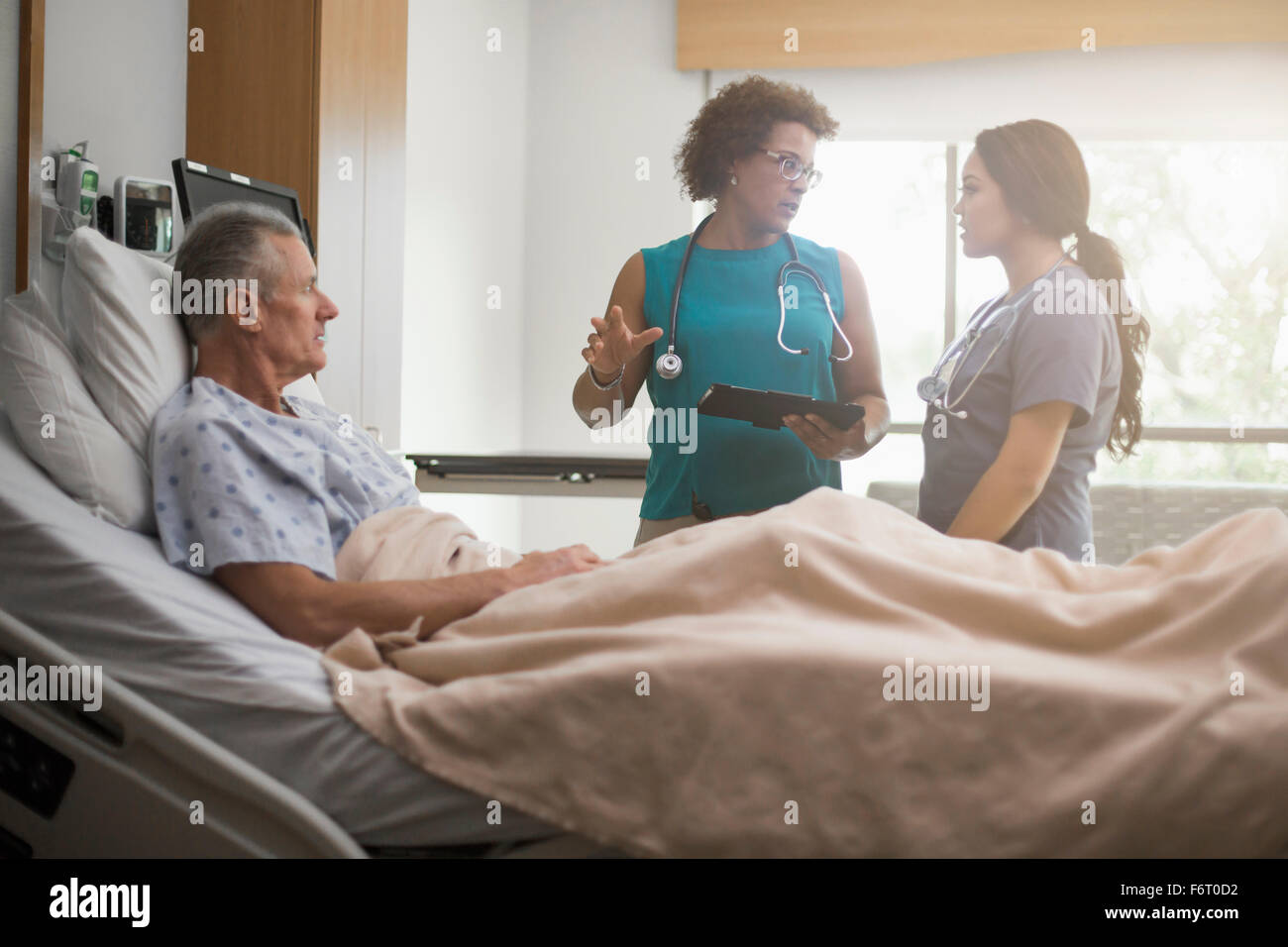 Arzt und Krankenschwester mit Patienten im Krankenzimmer Stockfoto