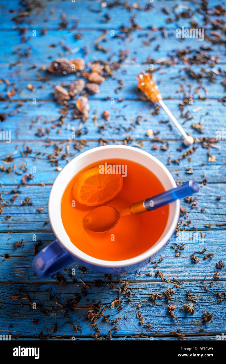 Tasse Tee mit Zitrone auf blauem Hintergrund aus Holz Stockfoto