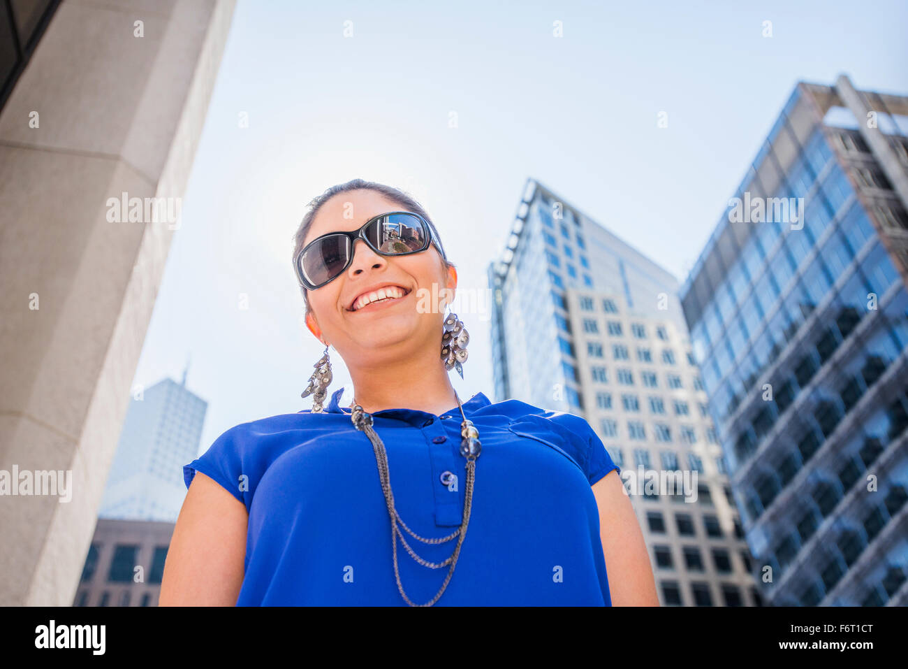 Hispanic Frau zu Fuß unter Hochhäuser Stockfoto
