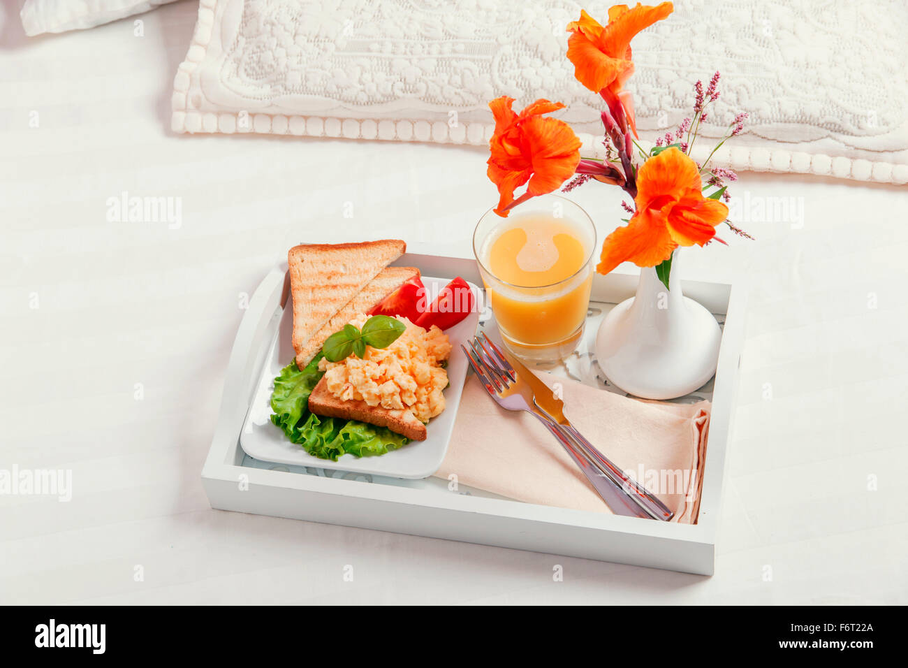 Frühstück auf einem Holztablett Eiern Rührei und Saft Stockfoto