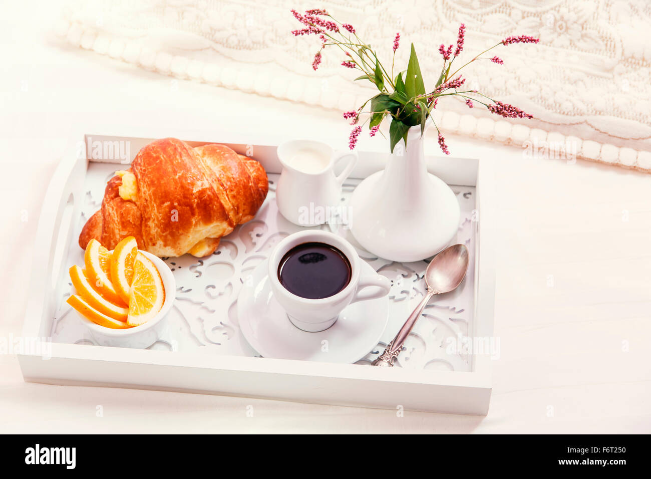 Frühstück auf Tablett aus Holz auf dem Bett Stockfoto