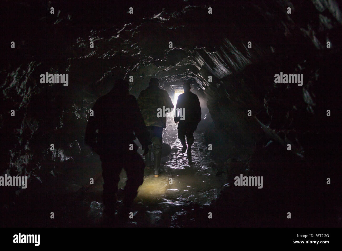 Männer gehen in dunklen Höhle Stockfoto