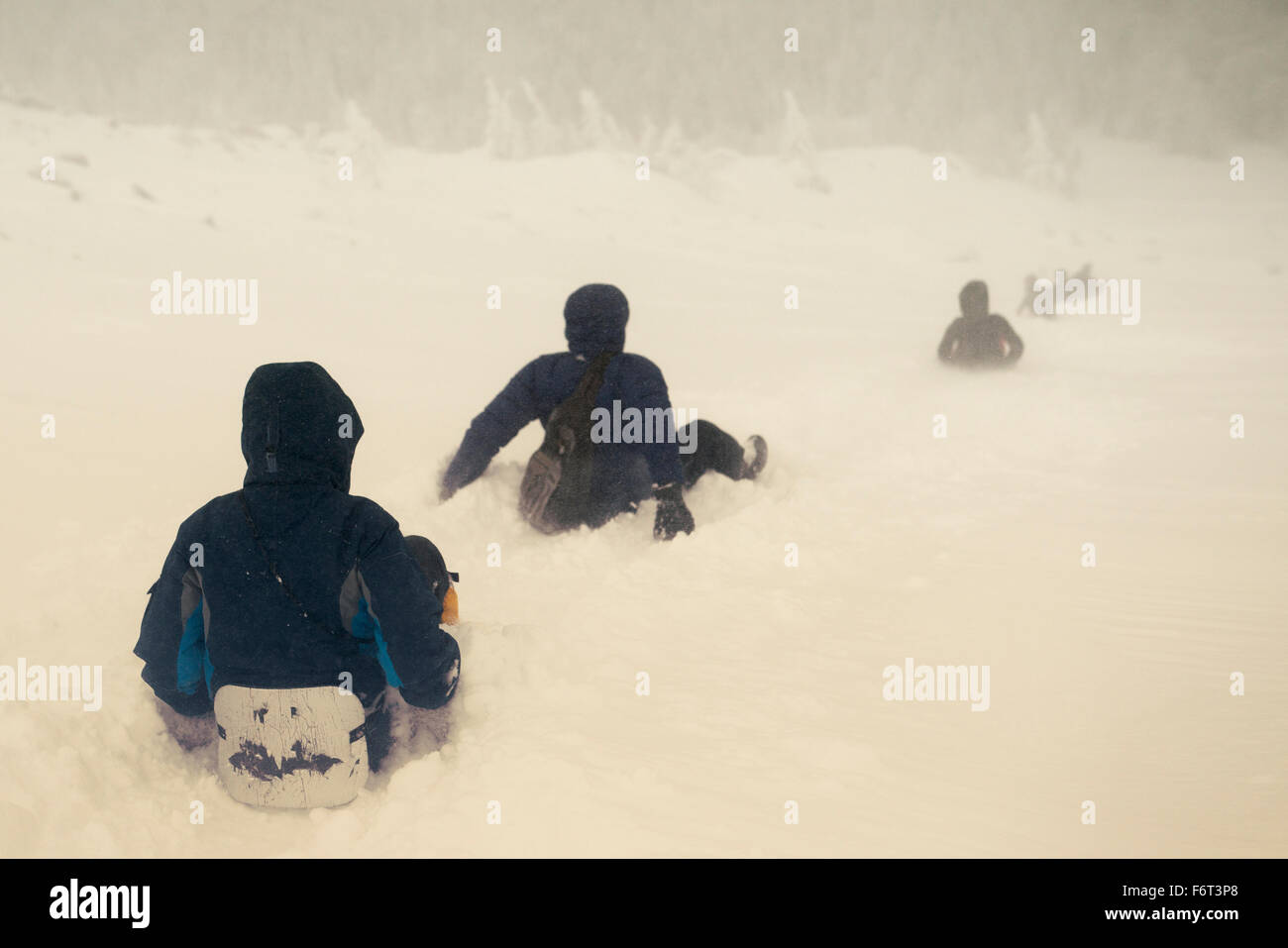Kaukasische Wanderer Rodeln auf verschneiten Hügel Stockfoto